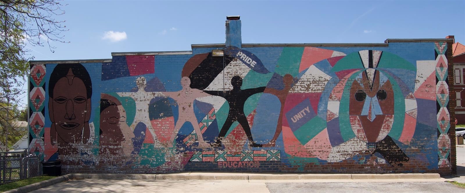 A mural featuring images of people on the side of a building